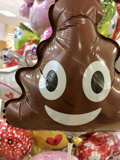 Ein brauner Ballon in Form des Kackehäufchen-Emojis.