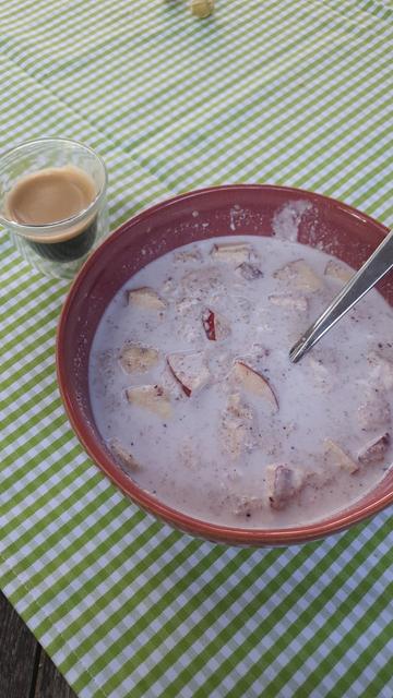 Müslischüssel und Espressotasse auf einem karierten Tischtuch