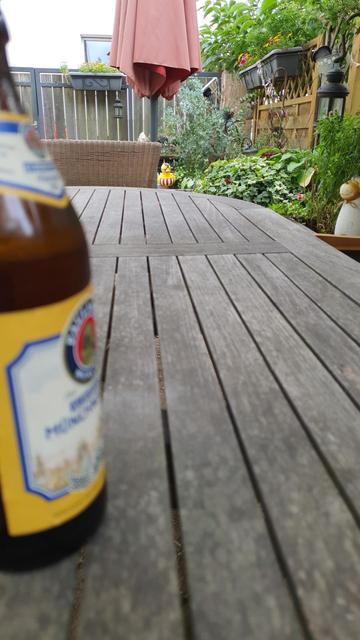 Links im Vordergrund ist unscharf eine Bierdflasche zu sehen. Im Hintergrund und an der Seite rechts sitzen eine Badeente und getöpfertes Schaf