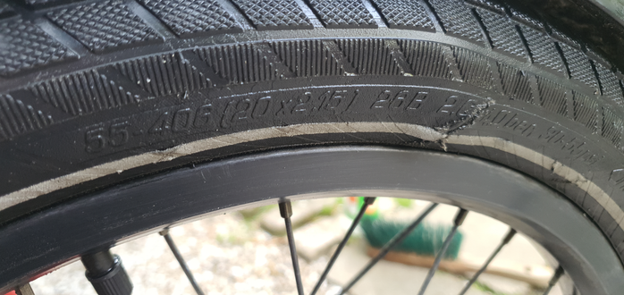 Foto eines Fahrradreifens. An der Seite des Mantels ist ein Riss von ca. 3-4cm Länge, der sich nach außen beult