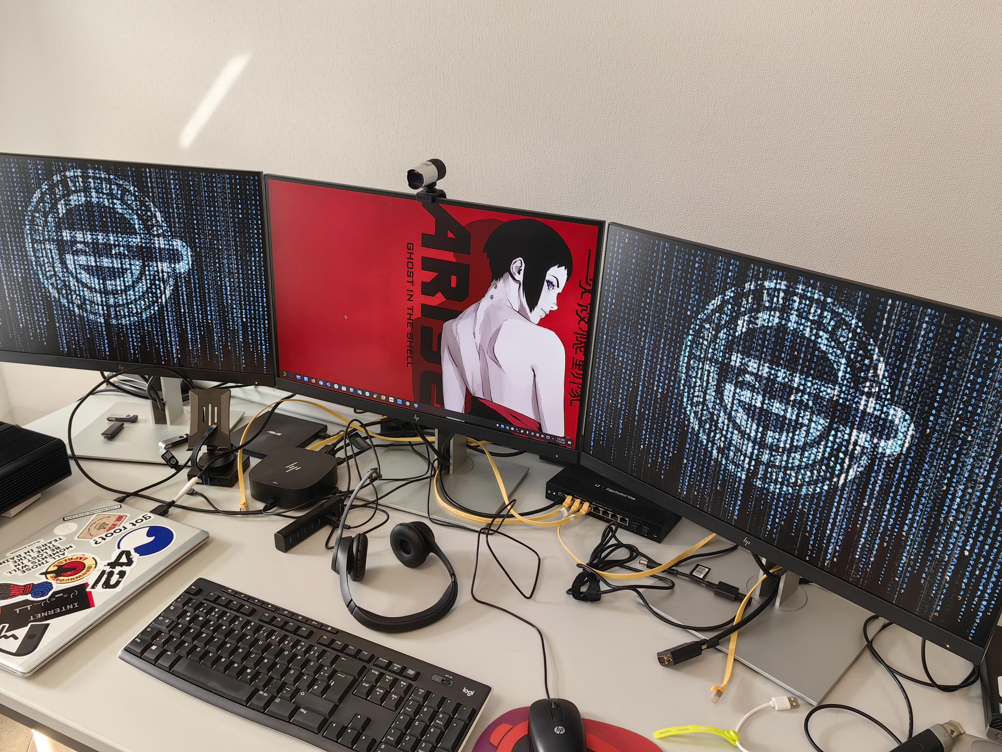 Arbeitsplatz mit 3 Monitoren. Die Hintergrundbilder haben ein Ghost in the Shell Thema.